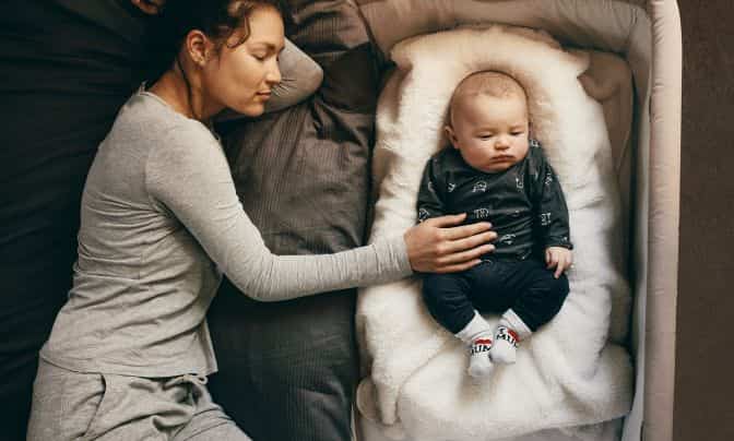 mamá cansada durmiendo con su bebé
